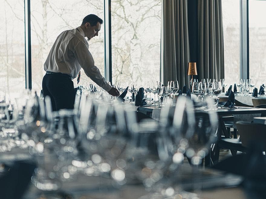 Miestarjoilija kattaa pöytiä valmiiksi. Tunnelmallisessa Bistrossa nautit illallista kahden kesken tai isommalla porukalla.